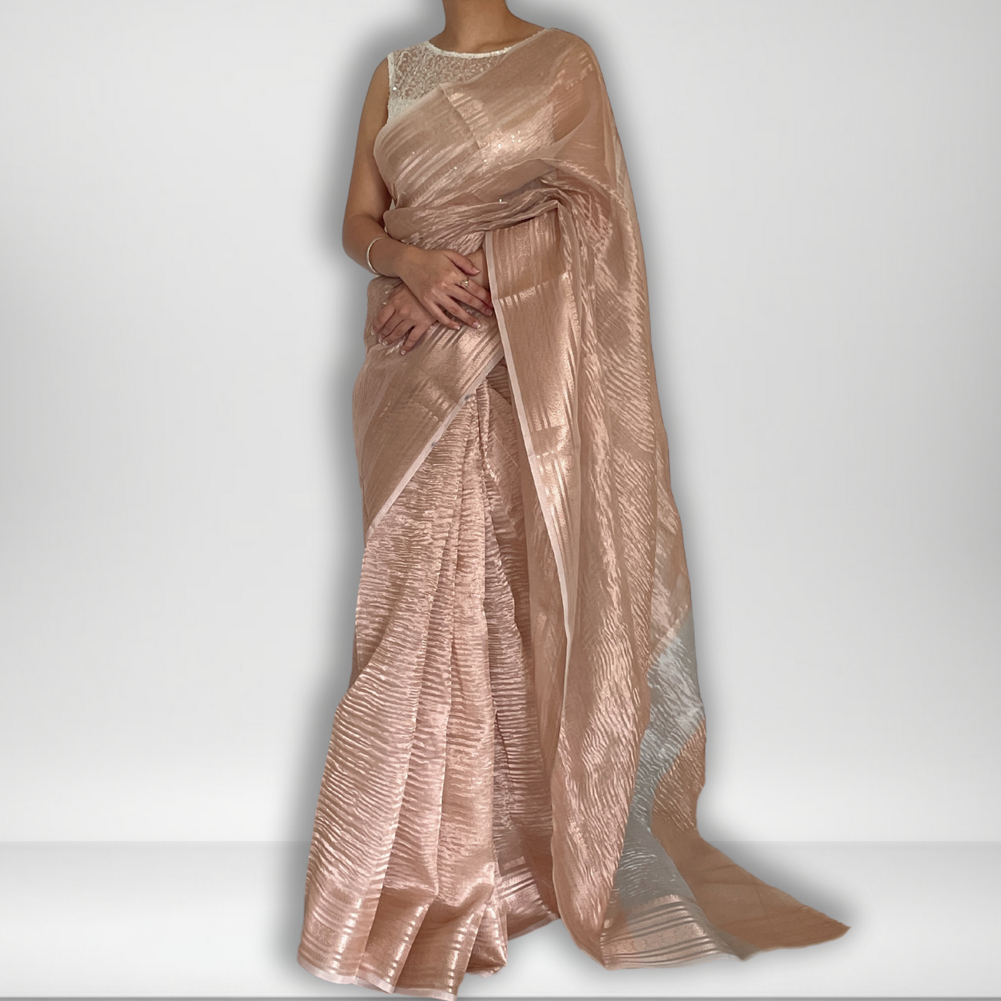 Rose gold metallic crush tissue saree with copper zari border, Work by Shobhangini. Trendy rose gold saree, ideal for festive celebrations.