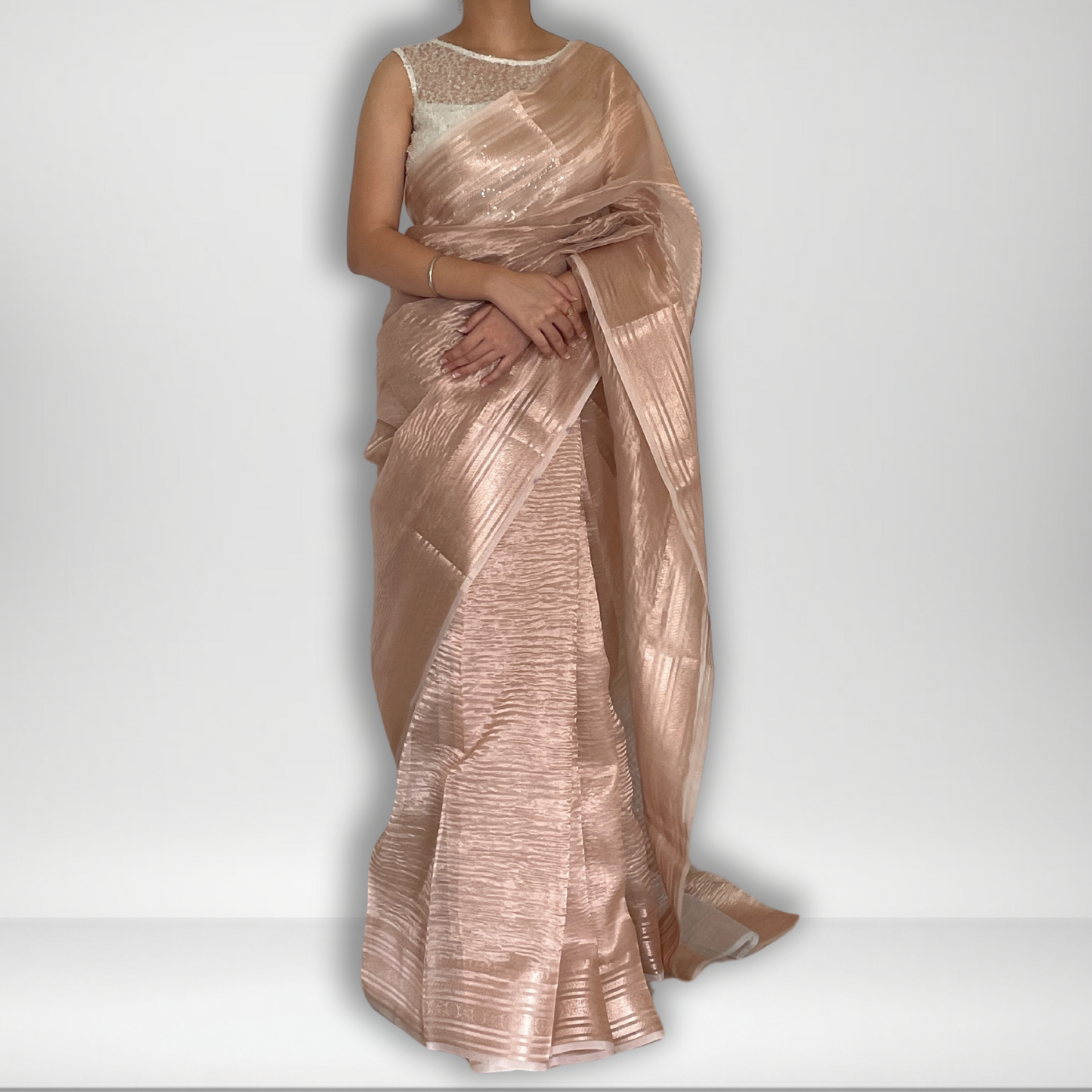 Rose gold metallic crush tissue saree with copper zari border, Work by Shobhangini. Trendy rose gold saree, ideal for festive celebrations.